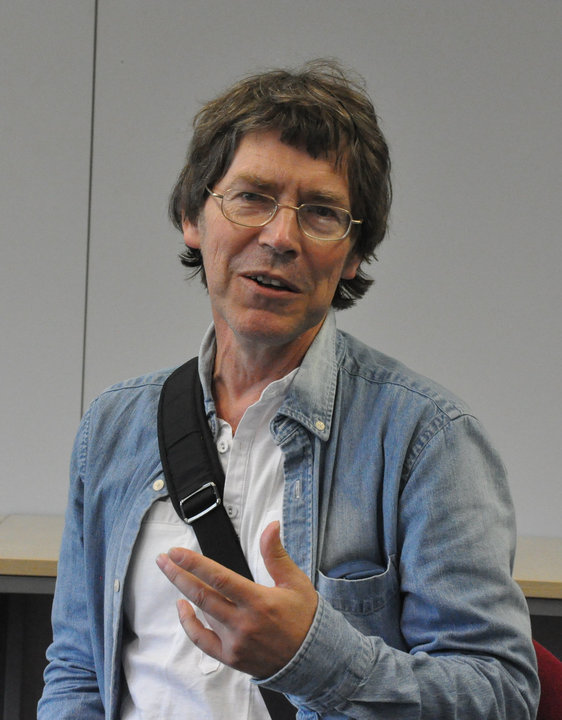 Bild på Ulf Ärnström i vit skjorta och blå jeansjacka med en svart väska över axeln.